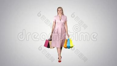 购物女人拿着购物走到镜头前的渐变背景。